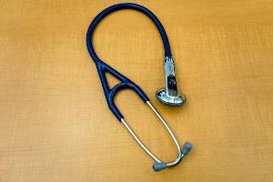 stethoscope with buttons resting on desk